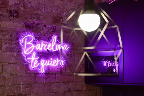 a neon sign on a brick wall with a light at Casa Maria Townhouse- terrace-4 bedrooms in Hospitalet de Llobregat