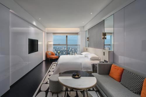 成都市にあるThe Langbo Chengdu, in The Unbound Collection by Hyattのベッドとソファのあるホテルの部屋
