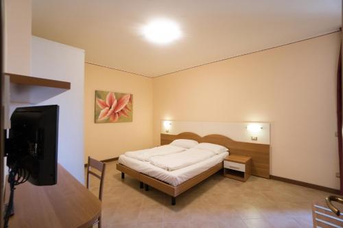 een slaapkamer met een bed en een flatscreen-tv bij Apartments "VILLA IMELDA" in Limone sul Garda