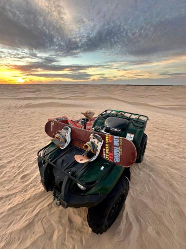 a green vehicle sitting in the sand in the desert at Camp Dunes Insolites Sabria in Sabria
