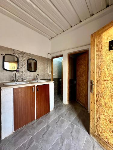 a kitchen with a sink and a door to a bathroom at Camp Dunes Insolites Sabria in Sabria
