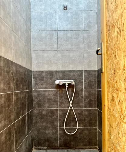 a shower with a hose in a bathroom at Camp Dunes Insolites Sabria in Sabria