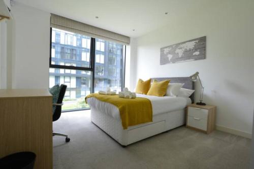 - une chambre avec un lit et une couverture jaune dans l'établissement The Simpson - Luxury 2 bed - Private Parking, à Édimbourg