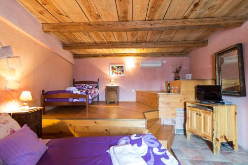 sala de estar con sofá púrpura y dormitorio en Rural Pension Istra Partner, en Barban