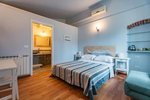 a bedroom with a bed with a striped bedspread at Caterina e l'Indaco in Sarzana