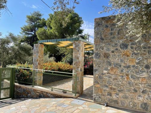 a gate to a garden with a stone wall at Ouzo Stone Studio in Plomarion