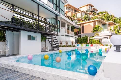 una piscina con bolas en el agua frente a un edificio en 哦先生的海景别墅, en Phuket