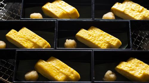 a bunch of trays filled with yellow food at Onyado Nono Kyoto Shichijo Natural Hot Spring in Kyoto