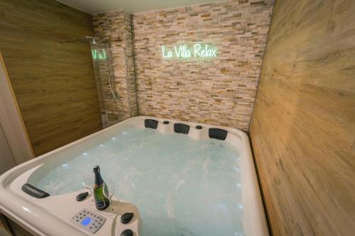une baignoire avec une bouteille de bière dedans dans l'établissement La Villa Relax SPA Luxe, à Amiens