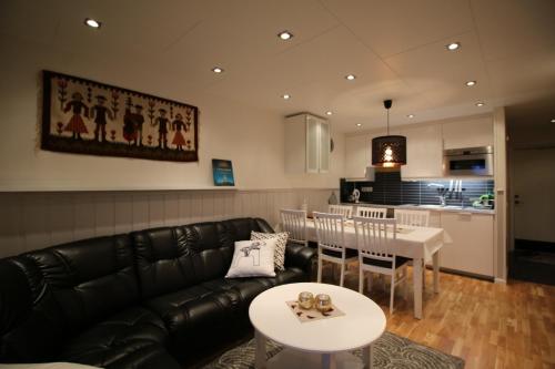 sala de estar con sofá, mesa y cocina en Gula Byn 411A, en Sälen
