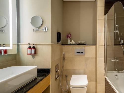 a bathroom with a toilet and a sink and a shower at Flora Inn Hotel Dubai Airport in Dubai