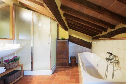 ein Badezimmer mit einer Badewanne und einem Waschbecken in der Unterkunft VILLA SAN NAZARIO 18&2, Emma Villas in Asciano