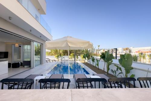 阿依納帕的住宿－City Napa Seaview Villas - Villa 8，一座带椅子和遮阳伞的建筑屋顶游泳池