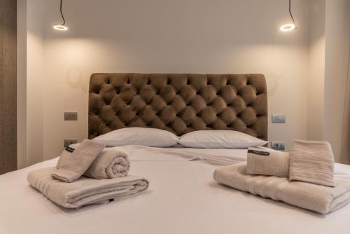 a bedroom with a large bed with towels on it at Nicolas Centrale-Smart City Suites in Igoumenitsa