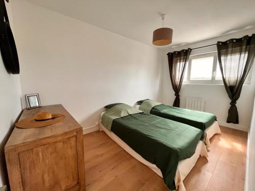 - une chambre avec 2 lits et une table en bois dans l'établissement Duplex familial proche gare et hyper centre ville, à Villepreux