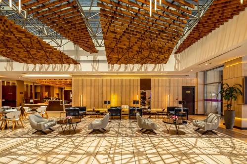 a lobby with chairs and tables in a building at Flora Inn Hotel Dubai Airport in Dubai