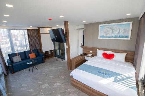 a hotel room with a bed and a flat screen tv at Lake View Hotel in Hanoi
