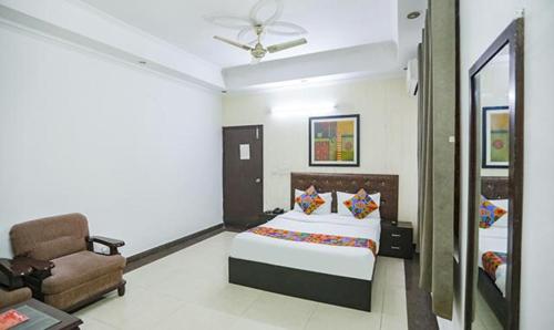 a bedroom with a bed and a chair at FabHotel F9 H Block Sector 51 in Noida