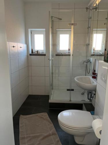 a bathroom with a shower and a toilet and a sink at Messewohnung/Monteurwohnung in Garbsen