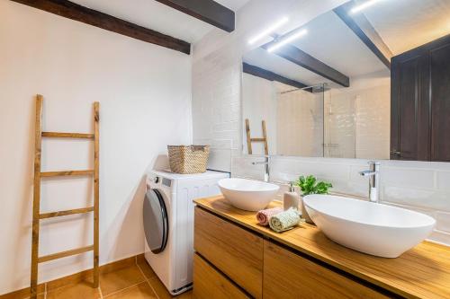 uma casa de banho com 2 lavatórios e uma máquina de lavar roupa em La iaia Rosita Preciosa casa tradicional Jávea em Jávea