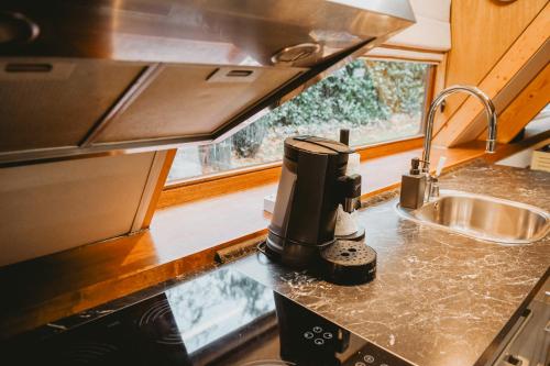 een keuken met een koffiezetapparaat op een aanrecht bij Boshuisje Rekem - Flora in Lanaken