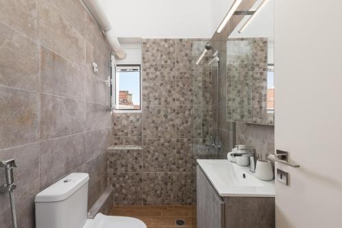 a bathroom with a toilet and a sink at Mikrolimano Gem: Serene 1BR Apartment in Piraeus