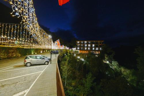 a car parked in front of a building with lights at Hotel Uji Ftohte Tepelene in Tepelenë