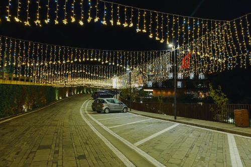 a car parked on a street with christmas lights at Hotel Uji Ftohte Tepelene in Tepelenë