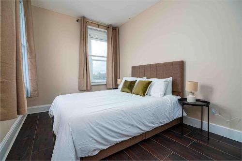 1 dormitorio con 1 cama grande y ventana en Cosy 2 Bed Flat In East London en Londres