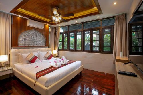 a bedroom with a bed with two stuffed animals on it at Tropical Escape: Kamala Beach in Kamala Beach