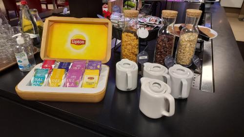 a table with a container of food and other snacks at Campanile Hotel Compiegne in Compiègne