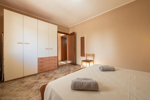 une chambre avec un lit avec deux serviettes dessus dans l'établissement Le Sabbie Bianche, à Calasetta