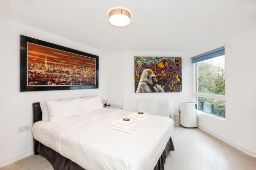 a white bedroom with a large bed and a window at Immaculate 2BR Flat, Greenwich, 2 min Maze Hill St in London