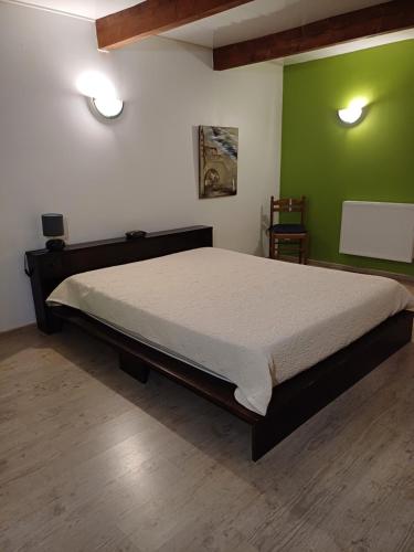 - un grand lit dans une chambre dotée d'un mur vert dans l'établissement chez Andréa, à Le Mont-Dore