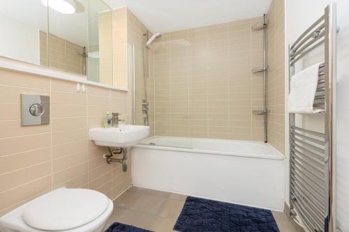 a bathroom with a toilet and a tub and a sink at Immaculate 2BR Flat, Greenwich, 2 min Maze Hill St in London