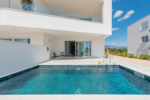 une image d'une maison avec une piscine dans l'établissement Apartments Twins with private pool, à Novalja