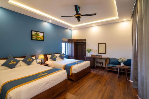 a hotel room with two beds and a ceiling fan at Coco Island Villa in Hoi An