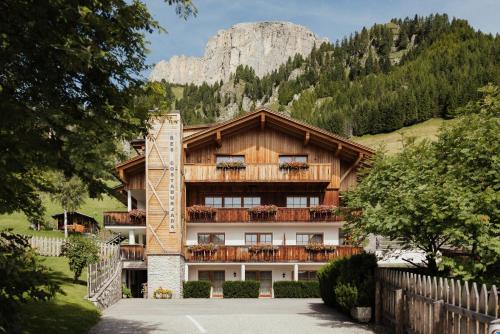 a building with a balcony with a mountain in the background at Residence Costa Burjada in Colfosco