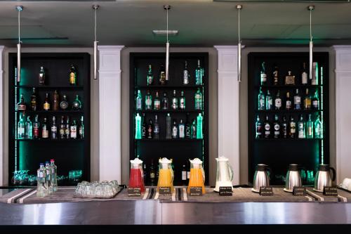 un bar avec des bouteilles d'alcool sur le mur dans l'établissement Villa Il Palagio, à Rignano sullʼArno