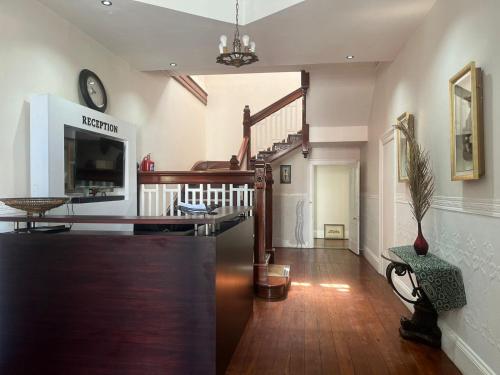 Uitenhage的住宿－HEBA GUEST LODGE，客厅铺有木地板,设有楼梯。
