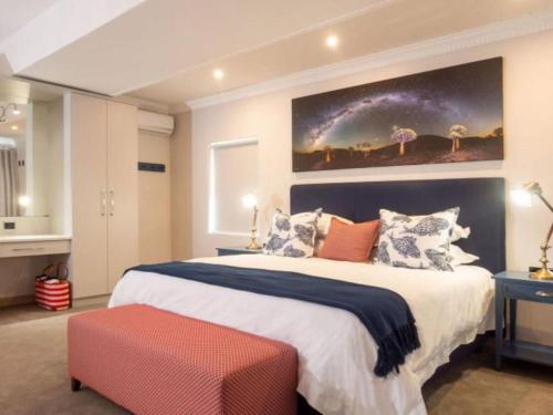 a bedroom with a large bed with a large painting on the wall at Hamilton House in Wilderness
