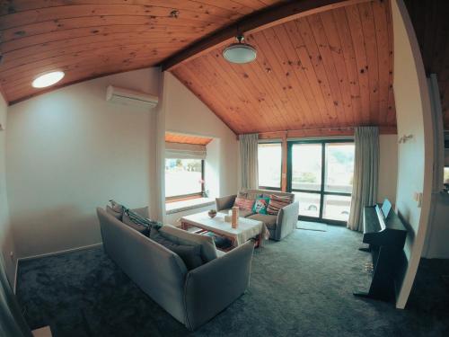 a living room with couches and a table at Auckland Sea&SkyTower view HOMESTAY with free Netflix, Parking in Auckland