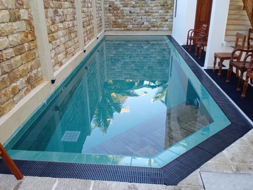 an infinity swimming pool with a tile floor and blue water at PearlDrop Waves Mirissa in Mirissa