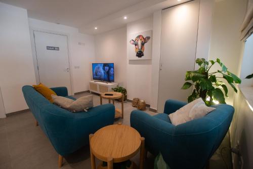uma sala de estar com duas cadeiras azuis e uma mesa em Gest em Mellieħa