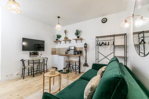 un salon avec un canapé vert et une table dans l'établissement MBA Splendide Appart - Popincourt Paris Centre, à Paris