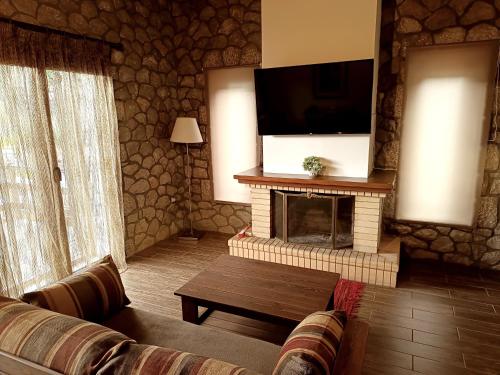 a living room with a fireplace with a flat screen tv at PS Apartment Polydrosos - PS Rental in Polydrossos