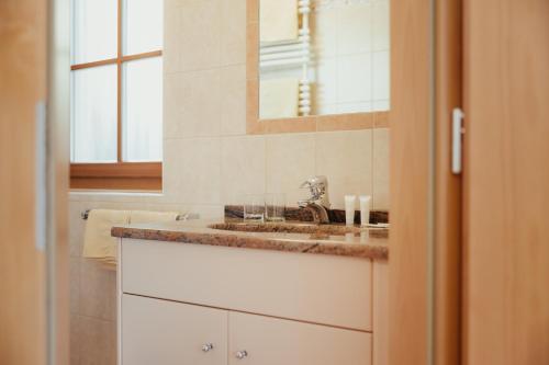 a bathroom with a sink and a mirror at Residence Costa Burjada in Colfosco