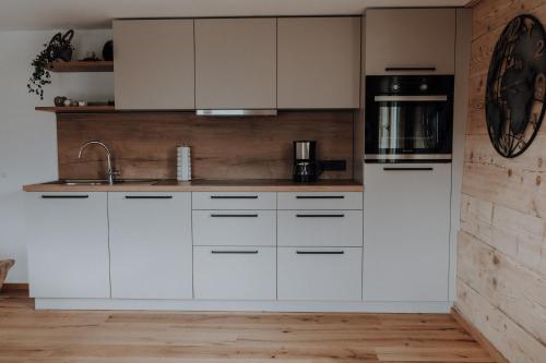 a kitchen with white cabinets and a sink at Haus Schäfer Zita in Fontanella