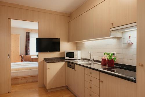 a kitchen with a sink and a microwave at Residence Costa Burjada in Colfosco