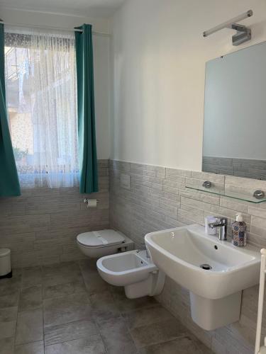 a bathroom with a sink and a toilet and a mirror at Seriana in Orio al Serio
